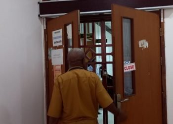 Marsel Mameyau, Sekretaris Dinas Kesehatan Kabupaten Mimika membuka pintu menunjukan pintu yang sudah digemboknya kepada Koranpapua.id, Senin 19 Juni 2023. (Foto : Redaksi/Koranpapua.id)