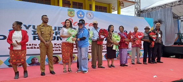 Seorang alumni menyerahkan bunga tangan kepada Margarita Abraham, Kepsek SDI Koperapoka 1.