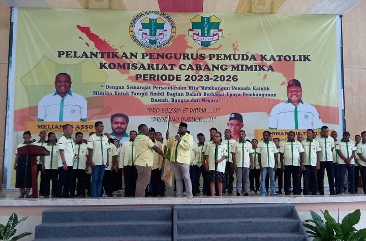 Dr. Leonardus Tumuka, Ketua Pemuda Katolik Komcab Mimika menerima penyerahan bendera petaka dari Melianus Asso, Ketua Pemuda Katolik Komda Papua.