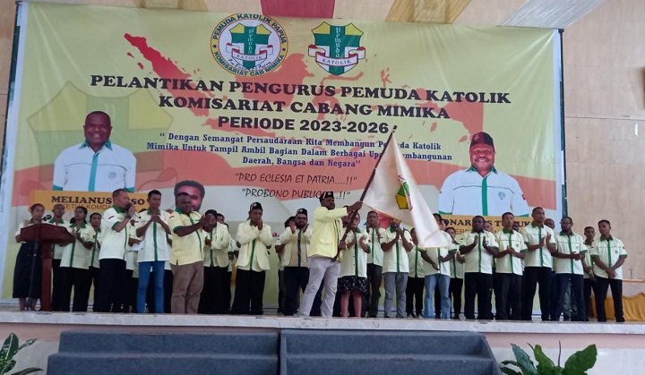 Dr. Leonardus Tumuka, Ketua Pemuda Katolik Komcab Mimika melambaikan bendera petaka disambut tepuk tangan.