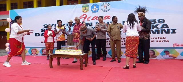 Margarita Abraham menyerahkan potongan kue HUT kepada Gregorius Okoare, perwakilan alumni.