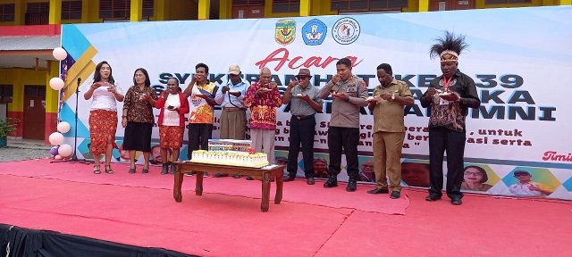 Kepala Dinas Pendidikan Mimika Dr. Willem Naa, S.Pd., M.MT, Gregorius Okoare, Kapolres Mimika AKBP I Gede Putra bersama mantan guru dan Kepsek Margarita Abraham bersama-sama makan kue.