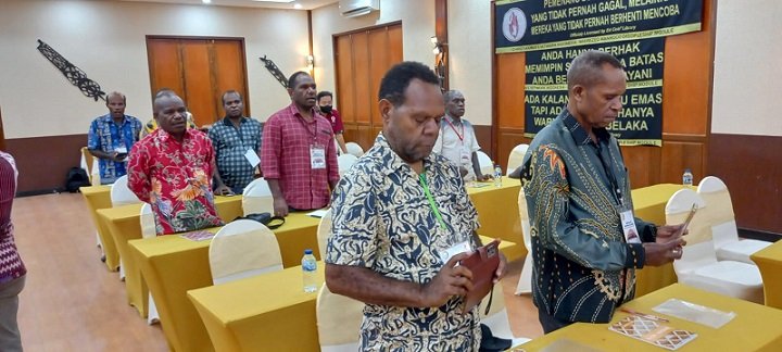 Pdt. Deky Pigome mengambil gambar video dengan HP saat ibadah berlangsung.