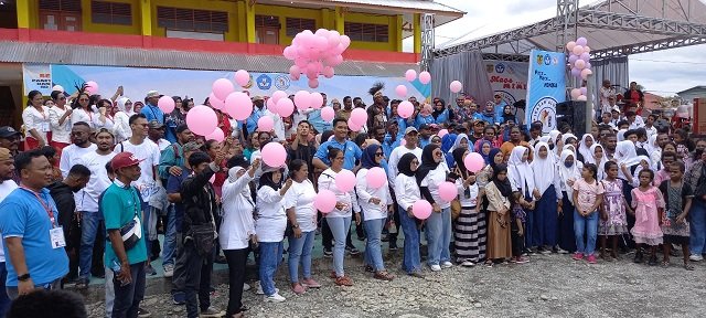 Para alumni bersuka cita mengangkat balon sebelum dilepas ke udara.