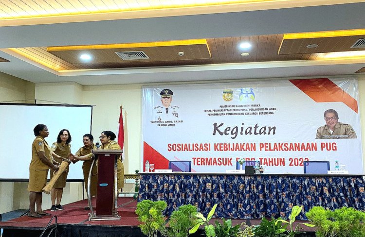 Bertha Beanal, Staf Ahli Bupati Bidang Kesejahteraan Rakyat dan SDM Setda Mimika bersama Kepala DP3AP2KB, Hermalina W. Imbiri menabuh tifa membuka kegiatan, Senin 24 Juli 2023. (Foto : Ist/Koranpapua.id)