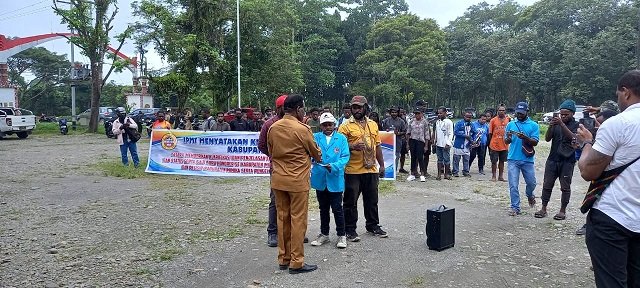 Hellois M. Kemong, Ketua IPMT menyerahkan aspirasi kepada Willem Naa, Plt Kepala Dinas Pendidikan Kabupaten Mimika di halaman Kantor Dinas Pendidikan, Senin 31 Juli 2023. (Foto : Redaksi/Koranpapua.id)
