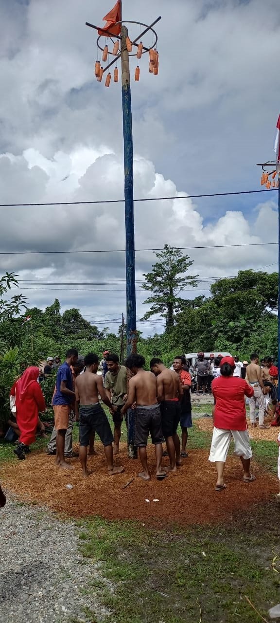 Para pemanjat pinang bersiap-siap memanjat untuk mengambil hadiah.