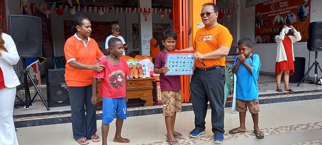 Sirhan Salilama, Ketua DPC Partai Buruh Mimika menyerahkan hadiah pemenang lomba makan kerupuk.