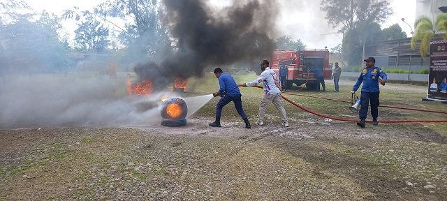 Personil Damkar BPBD Mimika mempraktekan memadamkan api menggunakan air dari mobil BPBD.