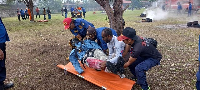 Petugas praktek mengevakuasi korban kebakaran menggunakan tandu.