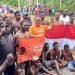 Sirhan Salilama, SH, Ketua DPC Partai Buruh Mimika bersama kader Buruh foto bersama para pemanjat pinang sambil membentangkan bendera Merah Putih dan bendera Buruh, Kamis 17 Agustus 2023.( Foto : Redaksi/Koranpapua.id)