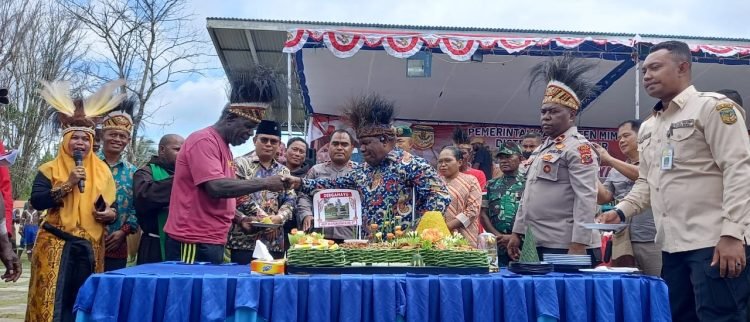 Pj. Sekda Mimika Petrus Yumte menyerahkan potongan tumpeng kepada ahli waris perintis Mapurujaya, Sabtu 19 Agustus 2023. (Foto : Redaksi/Koranpapua.id)