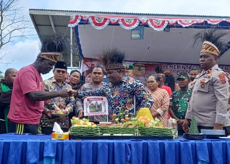 Pj. Sekda Mimika Petrus Yumte menyerahkan potongan tumpeng kepada ahli waris perintis Mapurujaya, Sabtu 19 Agustus 2023. (Foto : Redaksi/Koranpapua.id)
