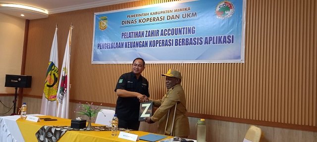 Dr. Andri Irawan, narasumber dari Universitas Yapis Papua menyerahkan aplikasi Zahir kepada Dr. Petrus Yumte, SH., M.Si Kepala Dinas Koperasi dan UMKM Mimika.