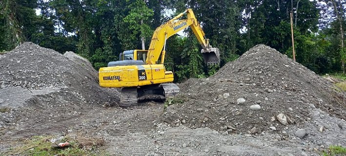 Sebuah excavator milik CV. Maina Jaya sementara meratakan timbunan untuk memasang gorong-gorong guna memasuki lokasi pembukaan jalan, Kamis 2 November 2023. (Foto : Redaksi/Koranpapua.id)
