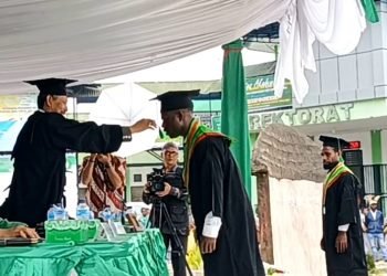 Rektor Universitas Amal Ilmiah Yapis Wamena, Dr. H. Rudihartono Ismail, M.Pd., CRA., CRP memindahkan tali toga salah satu wisudawan, Selasa 7 November 2023. (Foto : Ist./Koranpapua.id)
