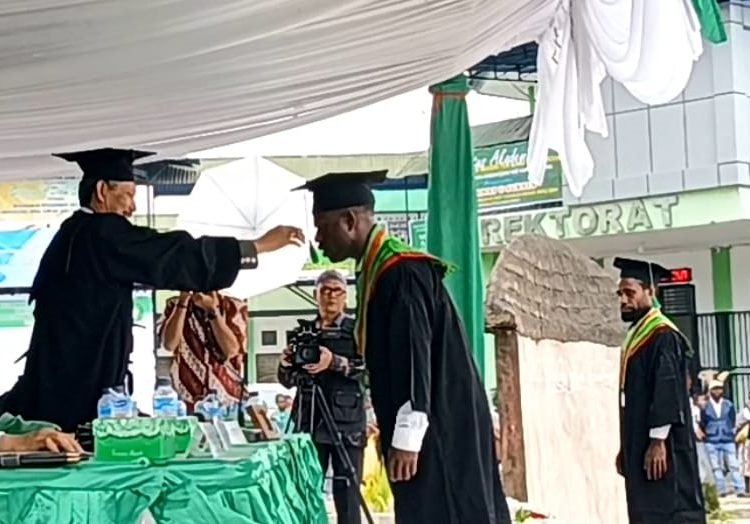 Rektor Universitas Amal Ilmiah Yapis Wamena, Dr. H. Rudihartono Ismail, M.Pd., CRA., CRP memindahkan tali toga salah satu wisudawan, Selasa 7 November 2023. (Foto : Ist./Koranpapua.id)