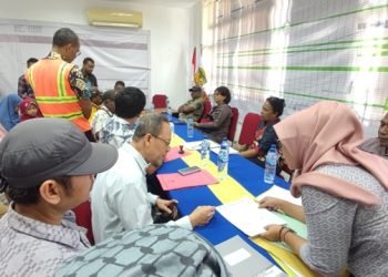 Warga pemilik tanah dampak pelebaran jalan menandatangani berita acara pembayaran ganti rugi di Kantor Dinas PUPR Mimika disaksikan anggota Polres Mimika Iptu Eduardus, Kamis 7 Desember 2023. (Foto : Ist./Koranpapua.id)