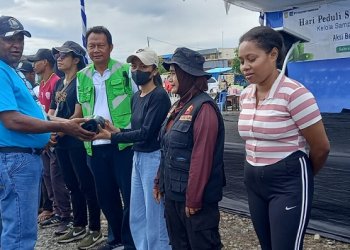 Frans Kambu, Plt. Kepala Dinas Lingkungan Hidup Mimika Papua Tengah menyerahkan material kerja kepada peserta, Sabtu 17 Februari 2024. (Foto : Redaksi/Koranpapua.id)