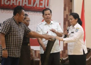 Pj Sekda Mimika, Dr. Ida Wahyuni bersama Kepala Badan Kesbangpol, Yan Selamat Purba memikul tifa membuka kegiatan Deklarasi Pemilih Cerdas, Rabu 7 Februari 2024. (Foto dok.ist/koranpapua.id)