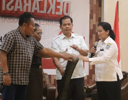 Pj Sekda Mimika, Dr. Ida Wahyuni bersama Kepala Badan Kesbangpol, Yan Selamat Purba memikul tifa membuka kegiatan Deklarasi Pemilih Cerdas, Rabu 7 Februari 2024. (Foto dok.ist/koranpapua.id)
