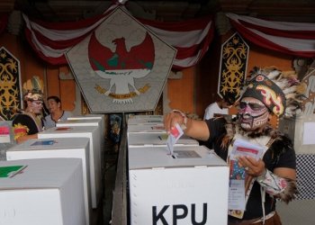 Petugas pemilihan mengenakan pakaian adat Papua saat pemilihan di TPS (Foto: Ist/Koranpapua.id)
